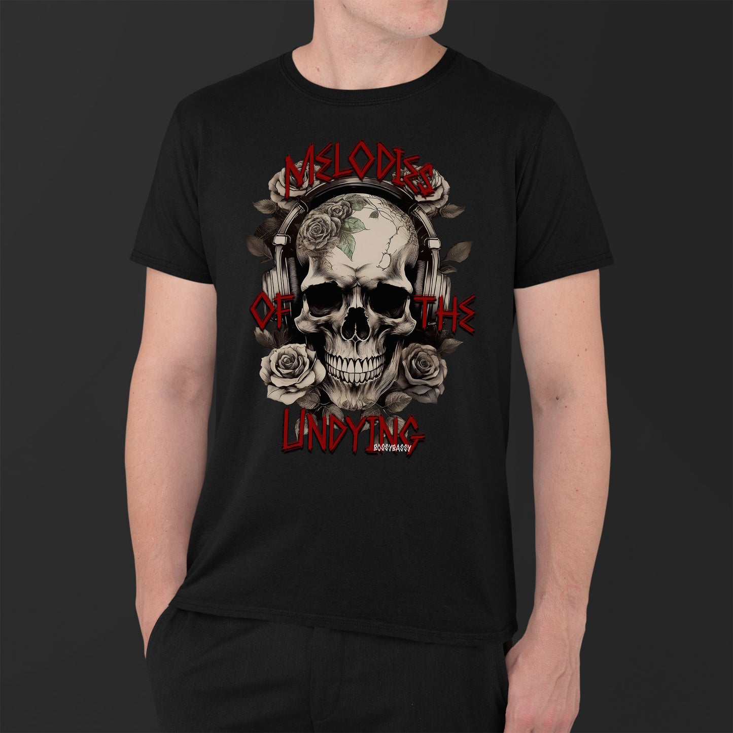 man wearing a black unisex tshirt features an illustration of a vintage skull skeleton with roses and the text Melodies of the Undying
