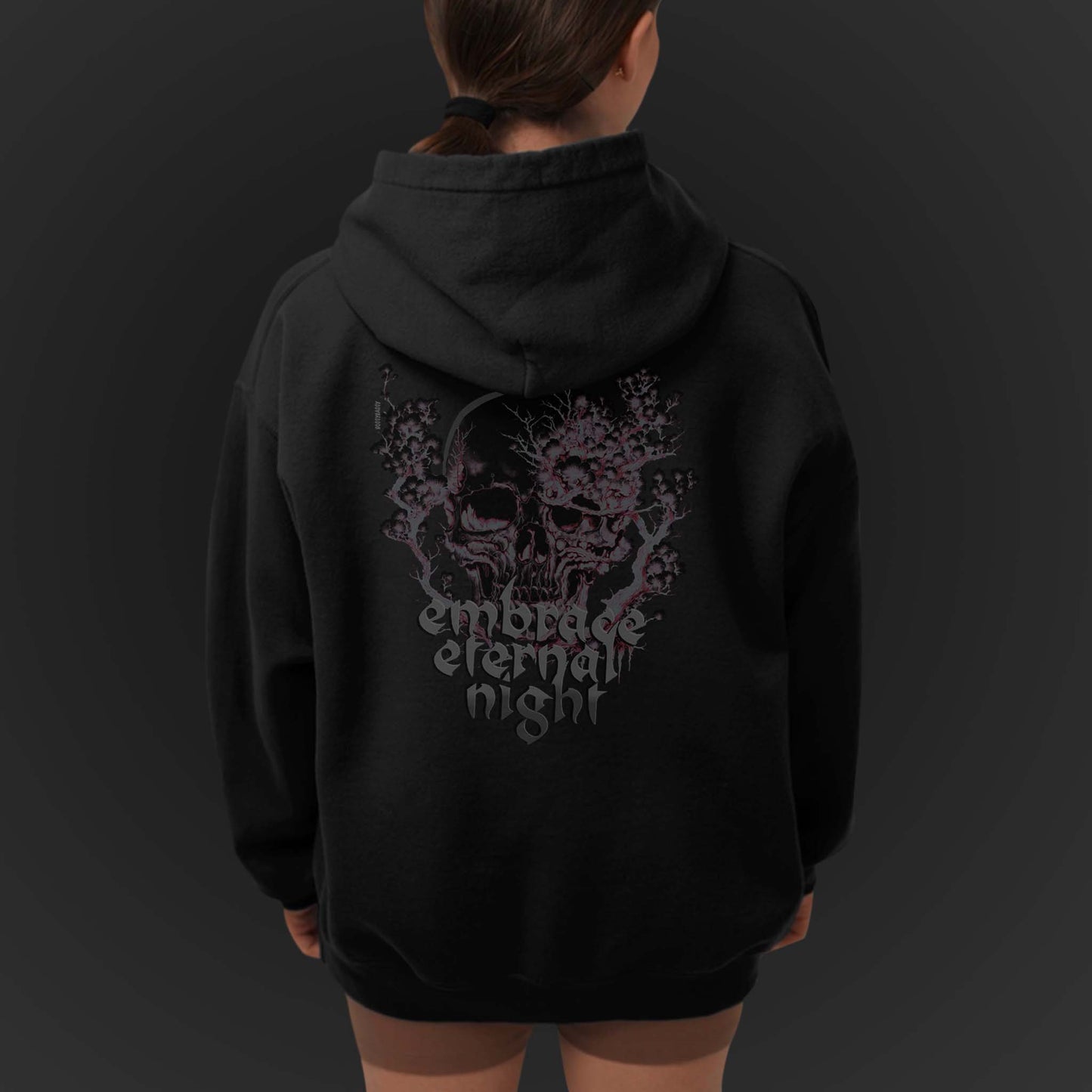 young-woman-wearing-a-black-sweatshirt-with-gothic-pink-and-black-skull-print-and-text-embrace-eternal-night